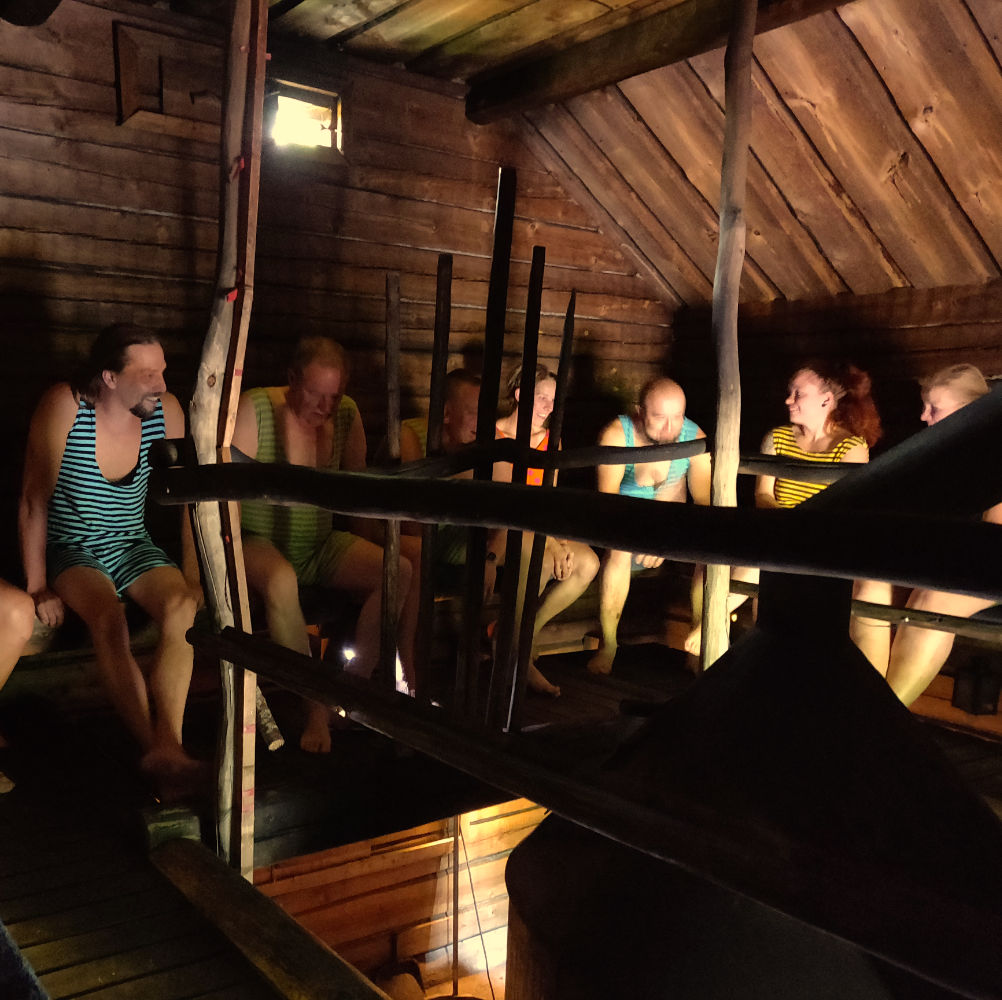 Miehiä ja naisia Saunatrikoot yllä isossa saunassa